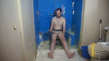 One man sitting on a low stool. His soles are visible. He's reading a piece of paper