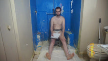 One man sitting on a low stool. Soles of feet are visible. He's looking at the camera