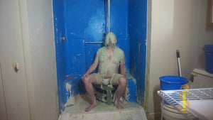 Man sitting with green slime falling on his head and face